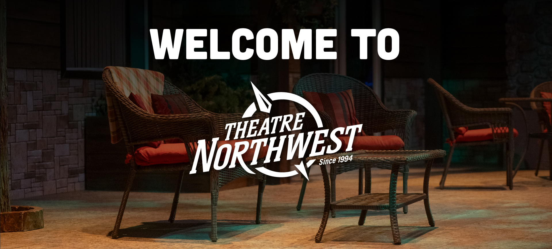 Header image featuring the bold text "Welcome to" followed by the Theatre Northwest logo. Text overlaying a dimly lit stage with red cushioned chairs and a table